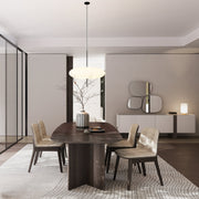 Modern dining room with wooden table and chairs, light fixture, and decorative elements.
