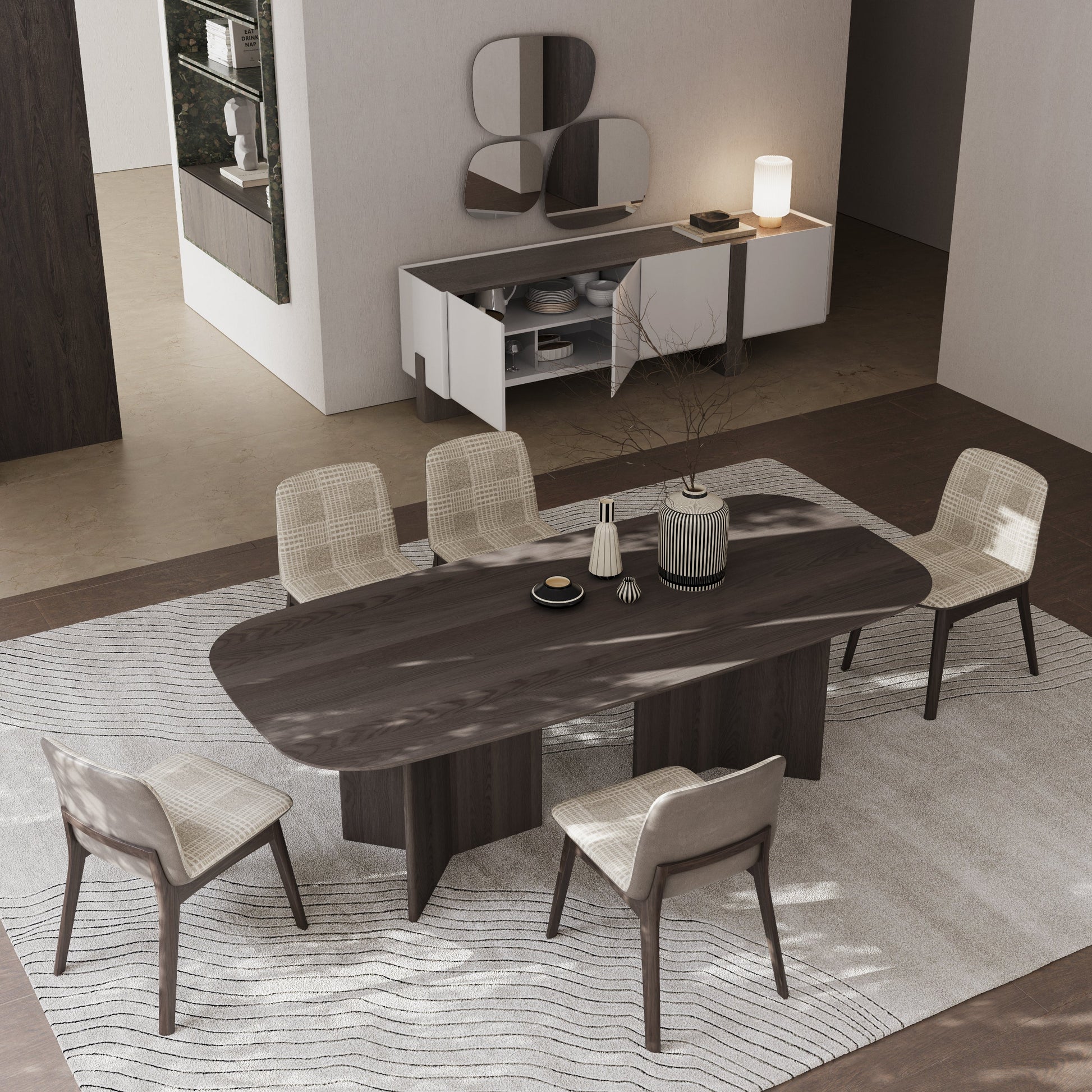 Dining room with a dark wooden table and chairs on a patterned rug.
