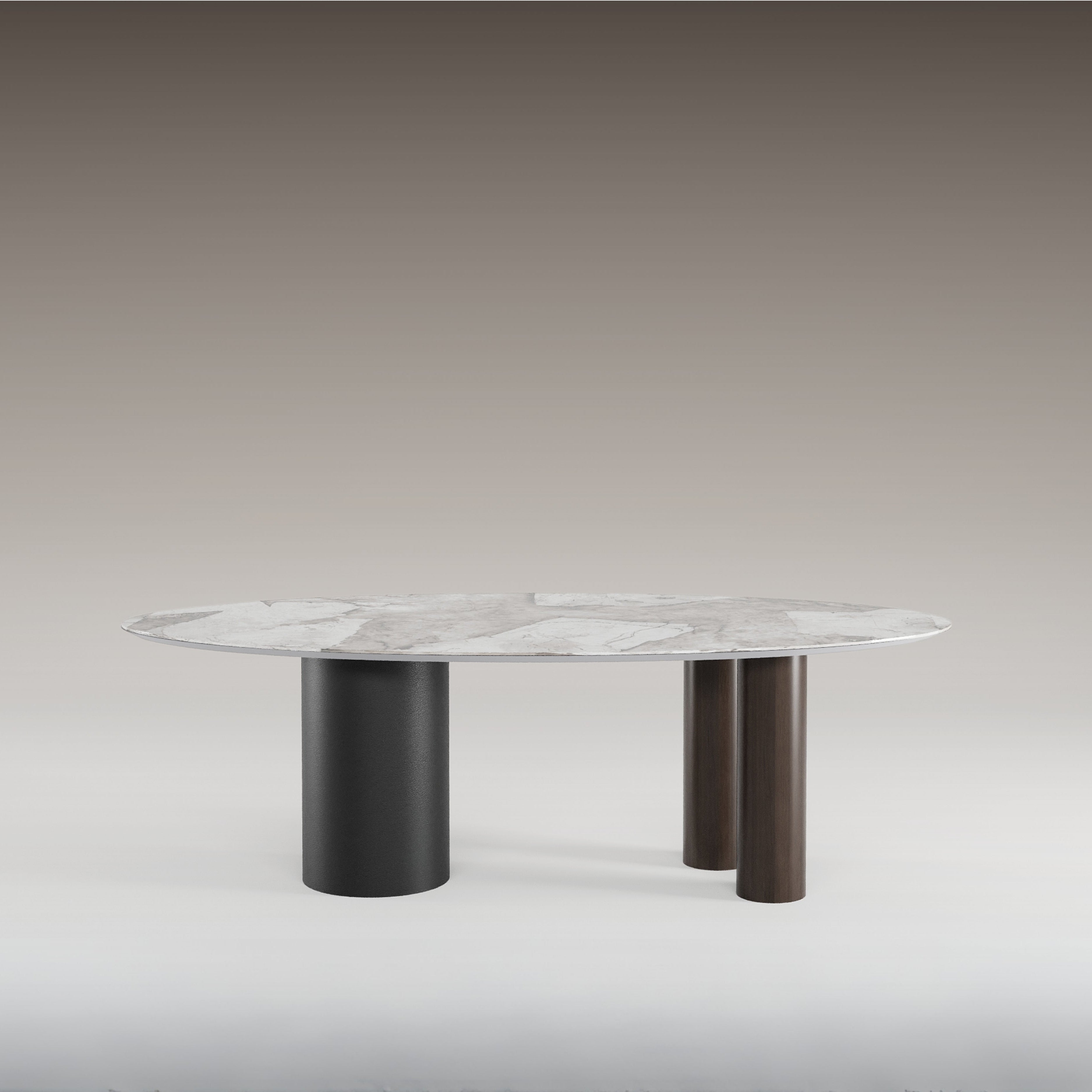Gamma Ceramic Wood Dining Table with sculptural black and brown cylindrical legs and an oval marble top.
