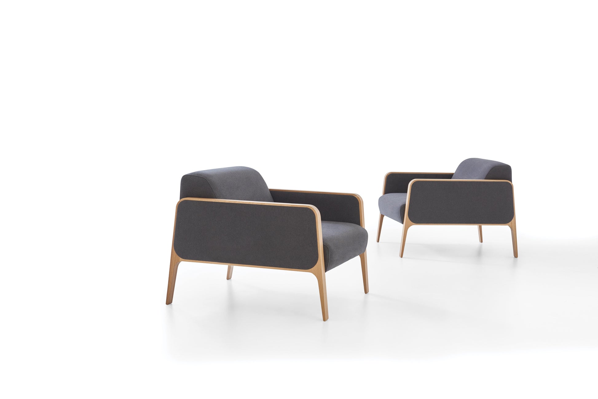 Two modern armchairs with dark gray seats and light wooden frames on a white background
