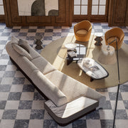 Modern living room with a checkered floor, gray modular sofa, and orange chairs.