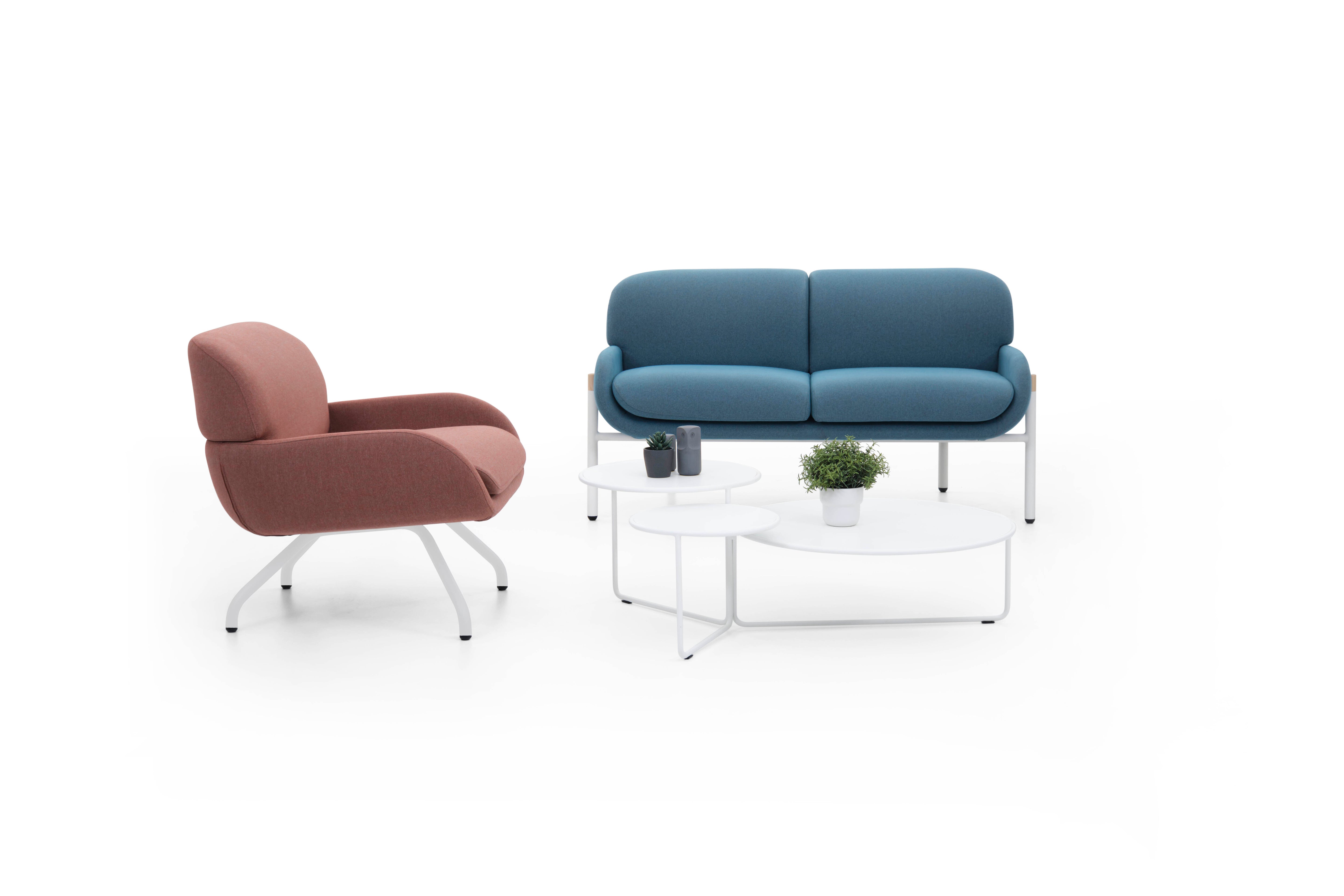 Brown armchair and blue sofa with a small table on a white background