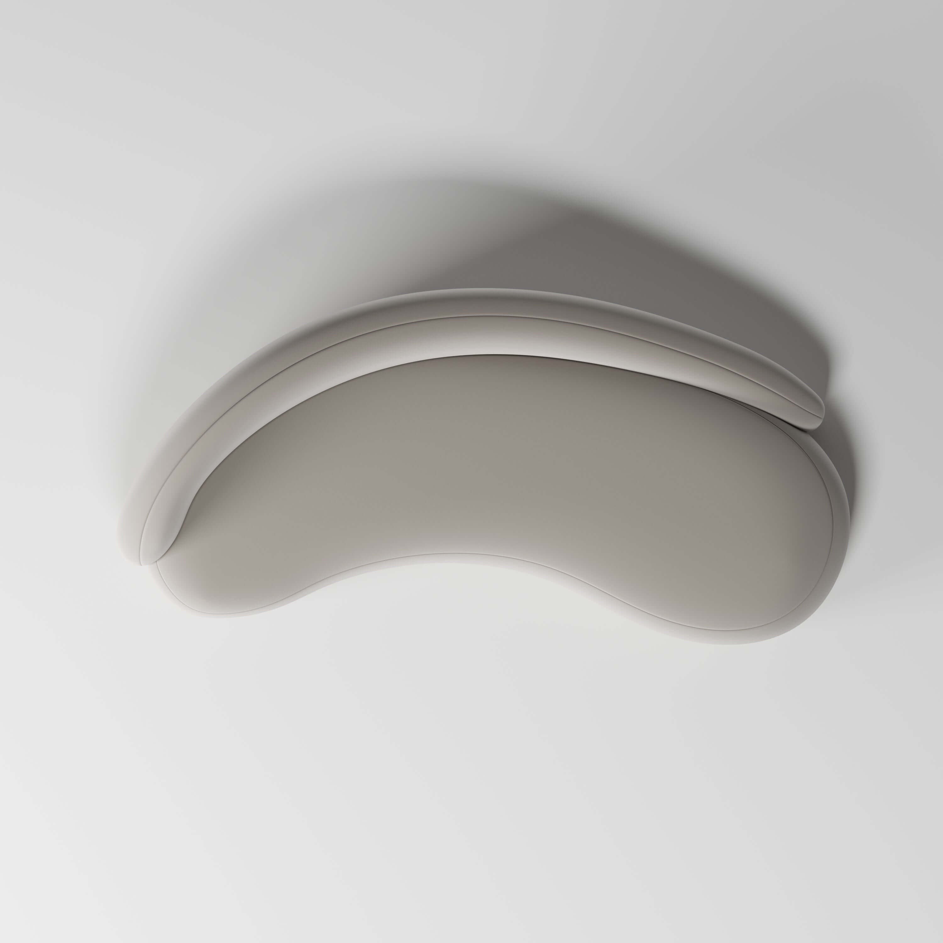 Top view of a modern, curved sofa cushion in a soft beige hue, designed for comfort and elegant aesthetics.