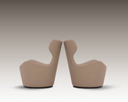 Side-by-side view of two Capri Armchairs in taupe leather with sculptural high backs, shown in mirrored positioning.