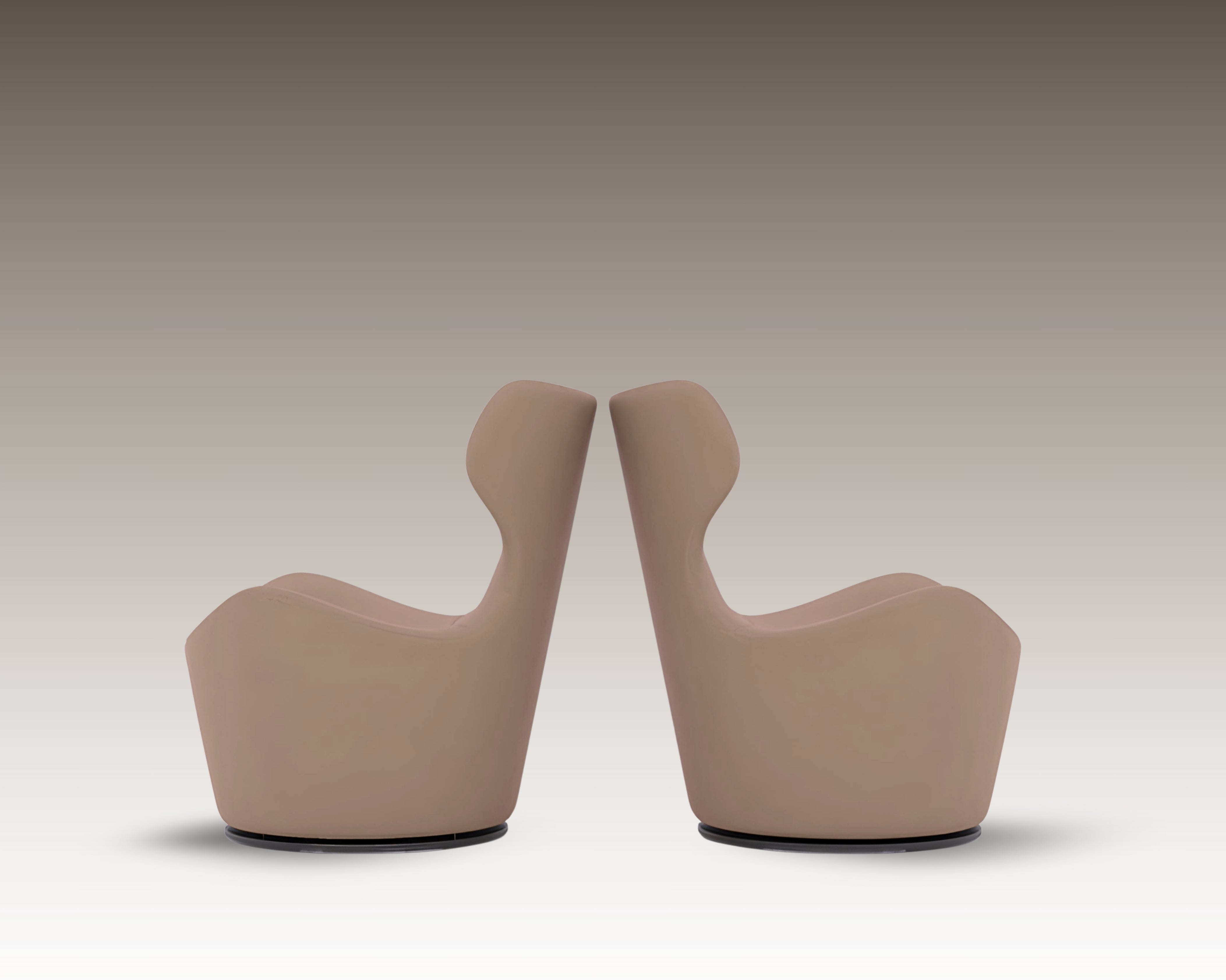 Side-by-side view of two Capri Armchairs in taupe leather with sculptural high backs, shown in mirrored positioning.