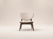 Lumora Chair by Canapy Furniture shown in a modern lounge setting with wood frame, upholstered seat and sculptural backrest