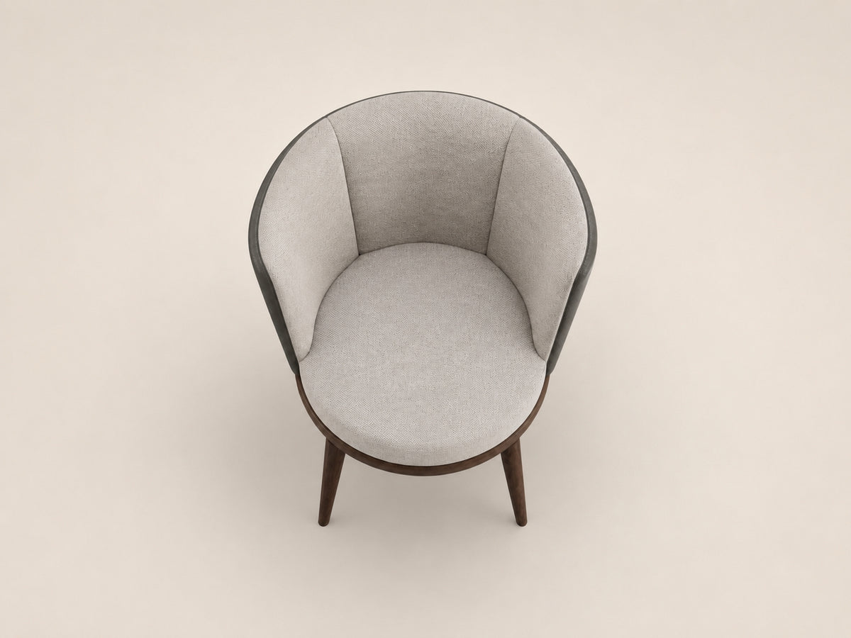 Lupa upholstered dining chair with tactile fabric, refined leather backing and graceful material contrast